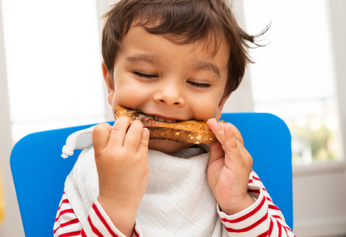 little boy eating sourdough bread