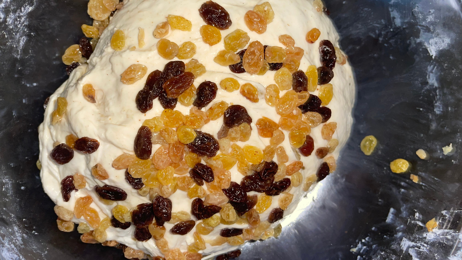 Raisins being folded into champagne sourdough dough during the third stretch and fold to preserve gluten strength and ensure even distribution