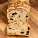 Soft cranberry pumpkin seed sourdough sandwich bread sliced to show the crumb, cranberries and pepitas